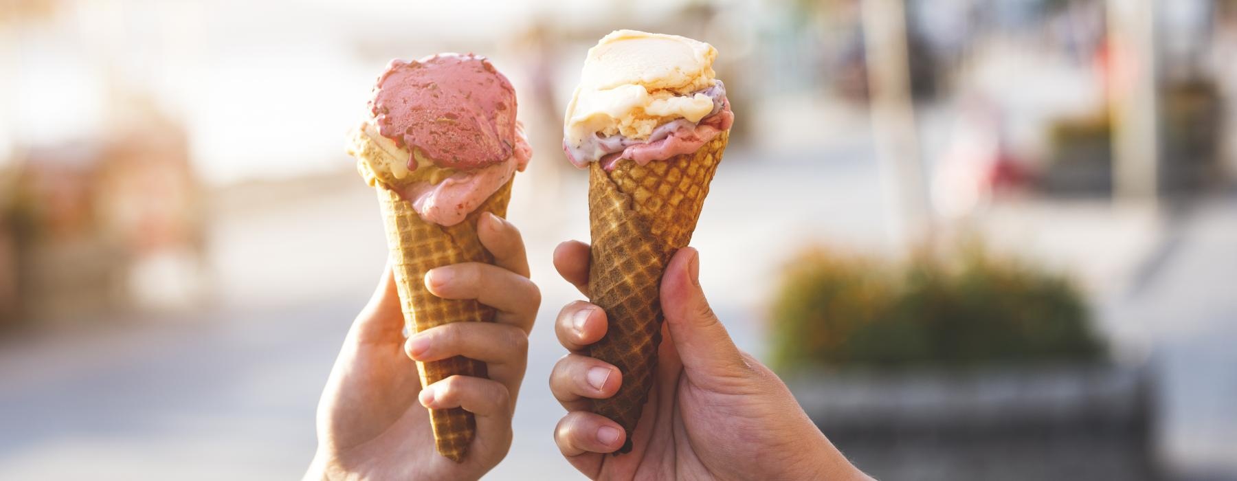 a group of hands holding ice cream cones